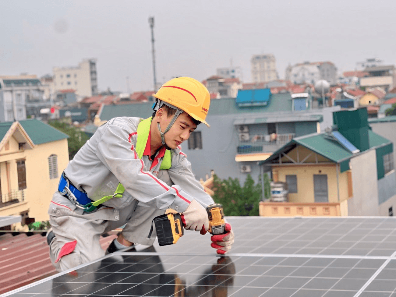 Construction worker wearing helmet and mask working on site with buildings in background
